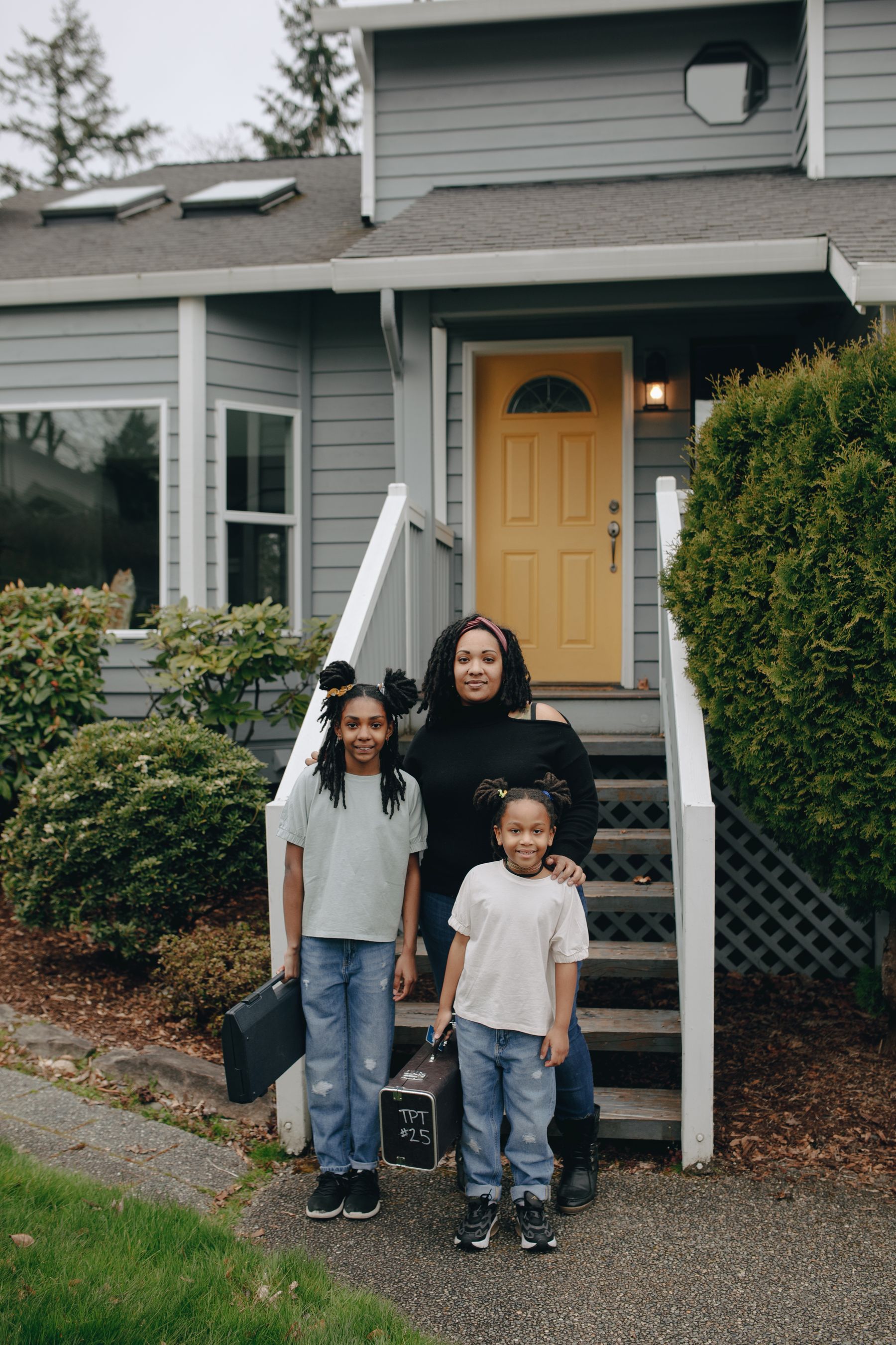 A family standing together outside their home